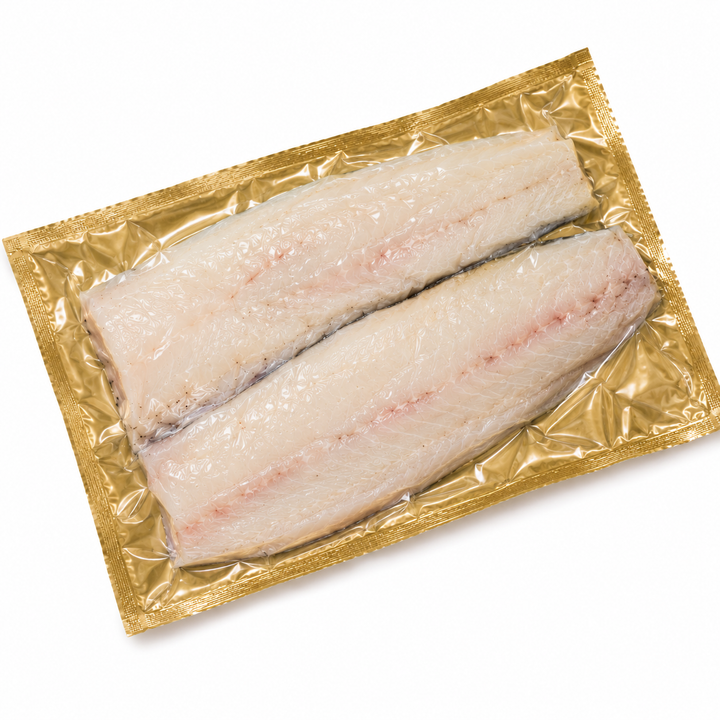 Two raw hake fish fillets in a gold packaging on a white background
