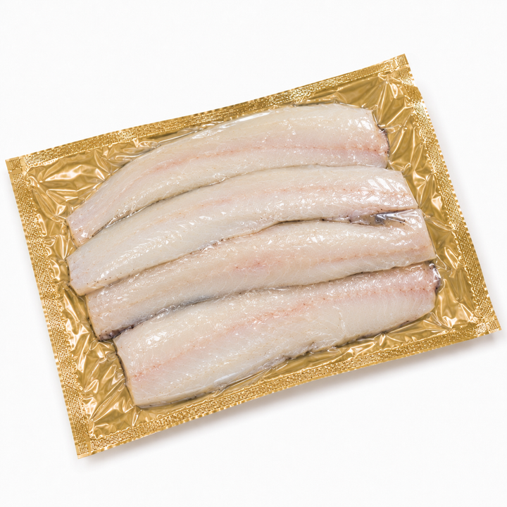 Packaged raw  hake fish fillets on a gold tray with a white background