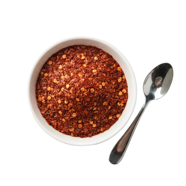 chilli flakes in a bowl with a plain background